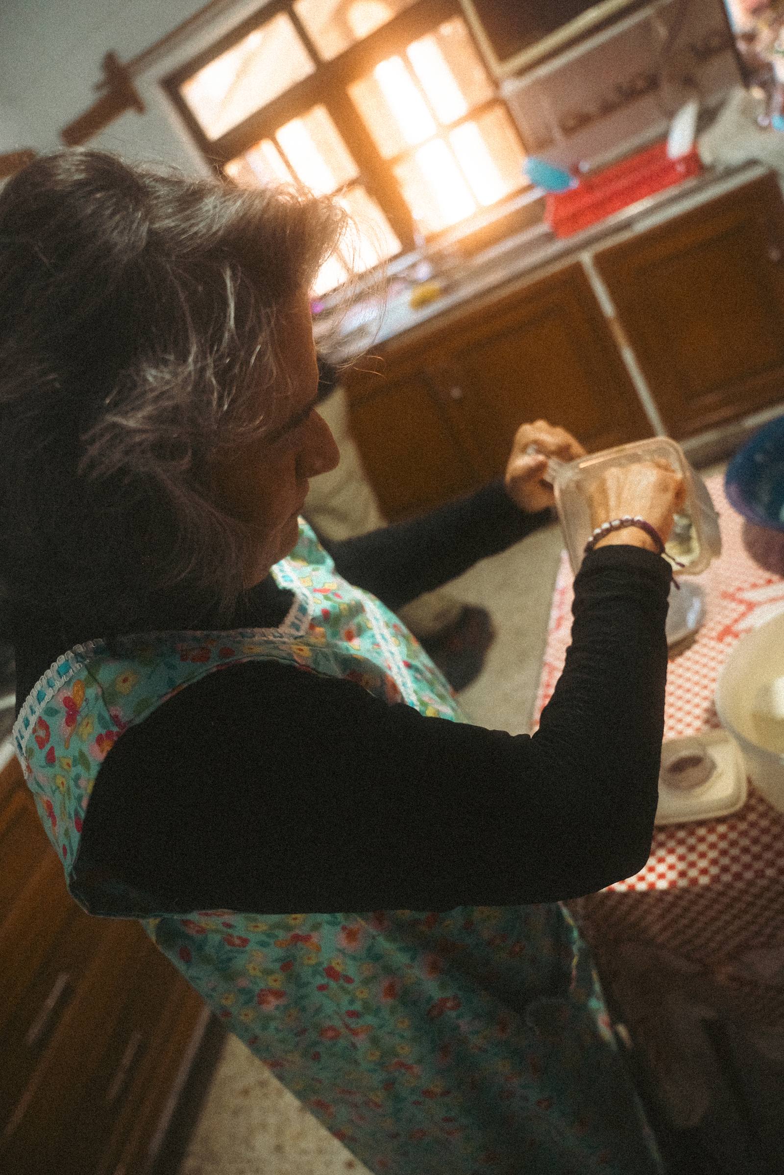 Doña Patricia con delantal enseñando a preparar tortillas a mano en el taller de cocina